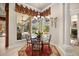 Bright dining area featuring a glass table, four chairs, decorative drapes, and view of screened patio at 401 Timberwalk Ln, Lake Mary, FL 32746