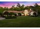 Sprawling single-story home with a tile roof, manicured landscaping, and sunset sky at 401 Timberwalk Ln, Lake Mary, FL 32746