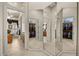 Hallway with triple-mirrored wall and access to a well-organized walk-in closet and bathroom at 401 Timberwalk Ln, Lake Mary, FL 32746