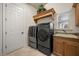 Laundry room features modern washer and dryer, plus upper cabinets and a sink at 401 Timberwalk Ln, Lake Mary, FL 32746