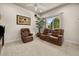 Relaxing living room with comfortable leather seating, palm tree, and view of the landscaped yard at 401 Timberwalk Ln, Lake Mary, FL 32746