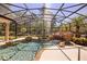 Serene screened pool featuring rock waterfall and lush foliage at 401 Timberwalk Ln, Lake Mary, FL 32746