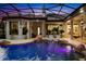 Enclosed pool featuring a rock waterfall, underwater lighting, and patio with white furniture at 401 Timberwalk Ln, Lake Mary, FL 32746