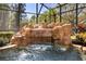 Close up of a rock waterfall feature in a screened pool area at 401 Timberwalk Ln, Lake Mary, FL 32746