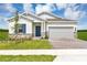 Charming single-story home with brick driveway, blue door, and manicured lawn under a partly cloudy sky at 4113 Jespersen St, Apopka, FL 32712