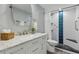 Bathroom with marble vanity, brushed nickel faucet, and white-tiled shower with blue accents at 601 W Old Us Highway 441 # 3-A, Mount Dora, FL 32757