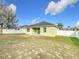 The backyard features an expansive lawn, a white fence, and the rear view of the home at 673 Highland Meadows Ave, Davenport, FL 33837