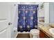 This bathroom features a toilet with cabinet and a patterned shower curtain at 673 Highland Meadows Ave, Davenport, FL 33837