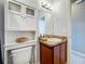 This bathroom features a vanity with granite countertop, a toilet with cabinet, and a mirror at 673 Highland Meadows Ave, Davenport, FL 33837