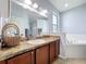 A primary bathroom features a double sink vanity, a large mirror, and a soaking tub at 673 Highland Meadows Ave, Davenport, FL 33837