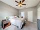 A bedroom features neutral walls and carpet, a ceiling fan, and a nightstand at 673 Highland Meadows Ave, Davenport, FL 33837