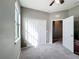 Neutral bedroom features a large window for ample natural light, a ceiling fan, and a closet at 673 Highland Meadows Ave, Davenport, FL 33837