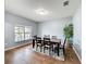 Elegant dining room with wood-look tile floors, a large window, and a modern light fixture at 673 Highland Meadows Ave, Davenport, FL 33837