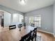 A dining room features a wood table and chairs atop an area rug with decor on the table and a window at 673 Highland Meadows Ave, Davenport, FL 33837