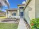 Inviting front porch with decorative landscaping, a pathway to the front door, and attractive architectural details at 673 Highland Meadows Ave, Davenport, FL 33837