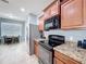 Modern kitchen with stainless steel appliances, granite countertops, and warm wood cabinetry at 673 Highland Meadows Ave, Davenport, FL 33837