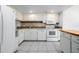 Well-lit kitchen features white cabinets, modern appliances, and tile backsplash at 710 Saint Matthew Cir # 710, Altamonte Springs, FL 32714