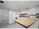 Modern kitchen with white cabinetry, butcher block island, and stainless appliances at 710 Saint Matthew Cir # 710, Altamonte Springs, FL 32714