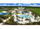 Aerial view of community featuring large resort pool, water slides, many palm trees and green spaces at 7463 Marker Ave, Kissimmee, FL 34747