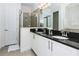 Bathroom featuring dual sinks with a dark countertop and a glass-enclosed shower at 7463 Marker Ave, Kissimmee, FL 34747