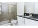 Tiled bathroom featuring a glass shower and vanity with granite countertop and modern fixtures at 7463 Marker Ave, Kissimmee, FL 34747