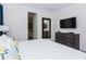 Bedroom with a gray dresser, a mounted TV, and an ensuite bathroom visible through an open door at 7463 Marker Ave, Kissimmee, FL 34747