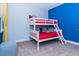 Bright bedroom featuring a white bunk bed with red mattresses against colorful blue accent walls at 7463 Marker Ave, Kissimmee, FL 34747