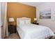 Bedroom showcasing a queen bed with decorative lamps on nightstands, set against a tan accent wall at 7463 Marker Ave, Kissimmee, FL 34747