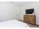 Neutral toned bedroom with white bedding, wooden dresser, and ample closet space at 7463 Marker Ave, Kissimmee, FL 34747