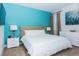 Bedroom with a tufted headboard, turquoise accent wall, a white dresser and two matching nightstands at 7463 Marker Ave, Kissimmee, FL 34747