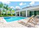 Inviting outdoor pool area with lounge chairs, covered patio, and well-maintained landscaping at 7463 Marker Ave, Kissimmee, FL 34747