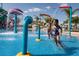 Children playing in the splash zone of the water park, with colorful water features and palm trees at 7463 Marker Ave, Kissimmee, FL 34747