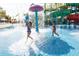 Community water park featuring children playing beneath a splash fountain and colorful water slides at 7463 Marker Ave, Kissimmee, FL 34747