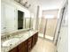 Bathroom boasts double sinks with granite counters, a large mirror, and a glass-enclosed shower at 7479 Marker Ave, Kissimmee, FL 34747