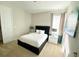 Neutral bedroom features a black accent wall bedframe, side tables with lamps, and lots of natural light at 7479 Marker Ave, Kissimmee, FL 34747