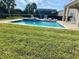 Inviting backyard pool with lounge chairs and a covered patio, perfect for relaxation and entertaining at 7479 Marker Ave, Kissimmee, FL 34747