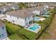 Aerial view of a backyard oasis with a pool and spa, complemented by lush landscaping and an outdoor dining area at 7483 Marker Ave, Kissimmee, FL 34747