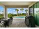 Covered patio featuring outdoor dining next to a beautiful pool with tropical landscaping at 7483 Marker Ave, Kissimmee, FL 34747