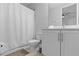 Bright bathroom with white vanity, toilet, shower with curtain and tile flooring at 7483 Marker Ave, Kissimmee, FL 34747