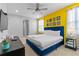 Inviting bedroom with a striking yellow accent wall and modern decor at 7483 Marker Ave, Kissimmee, FL 34747