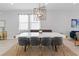 Bright dining room featuring modern chandelier, gray chairs, and white table at 7483 Marker Ave, Kissimmee, FL 34747