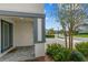 Covered entryway featuring stylish blue-gray pillars, a brick paver walkway, and lush landscaping at 7483 Marker Ave, Kissimmee, FL 34747