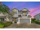 Charming two-story home with a two car garage and balcony, complemented by a brick driveway at 7483 Marker Ave, Kissimmee, FL 34747