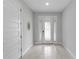 Bright foyer with a decorative gold starburst mirror and a white textured front door at 7483 Marker Ave, Kissimmee, FL 34747