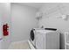 Functional laundry room with washer, dryer, and wire shelving at 7483 Marker Ave, Kissimmee, FL 34747