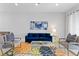 Inviting living room with a blue sofa, neutral-toned chairs, and decor, bathed in natural light at 7483 Marker Ave, Kissimmee, FL 34747