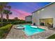 Beautiful backyard with a sparkling pool and spa under a vibrant, colorful sky, perfect for relaxation and evening entertainment at 7483 Marker Ave, Kissimmee, FL 34747