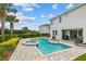 Relaxing backyard featuring a sparkling pool, spa, lounge chairs and a meticulously paved deck, perfect for outdoor enjoyment at 7483 Marker Ave, Kissimmee, FL 34747