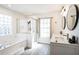 Bright bathroom with double sinks, modern lighting, tiled walls, and a glass-enclosed shower at 768 Park Valley Cir, Minneola, FL 34715