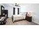 Bedroom with neutral tones, wood floors, and a ceiling fan above a bed with a padded headboard at 768 Park Valley Cir, Minneola, FL 34715